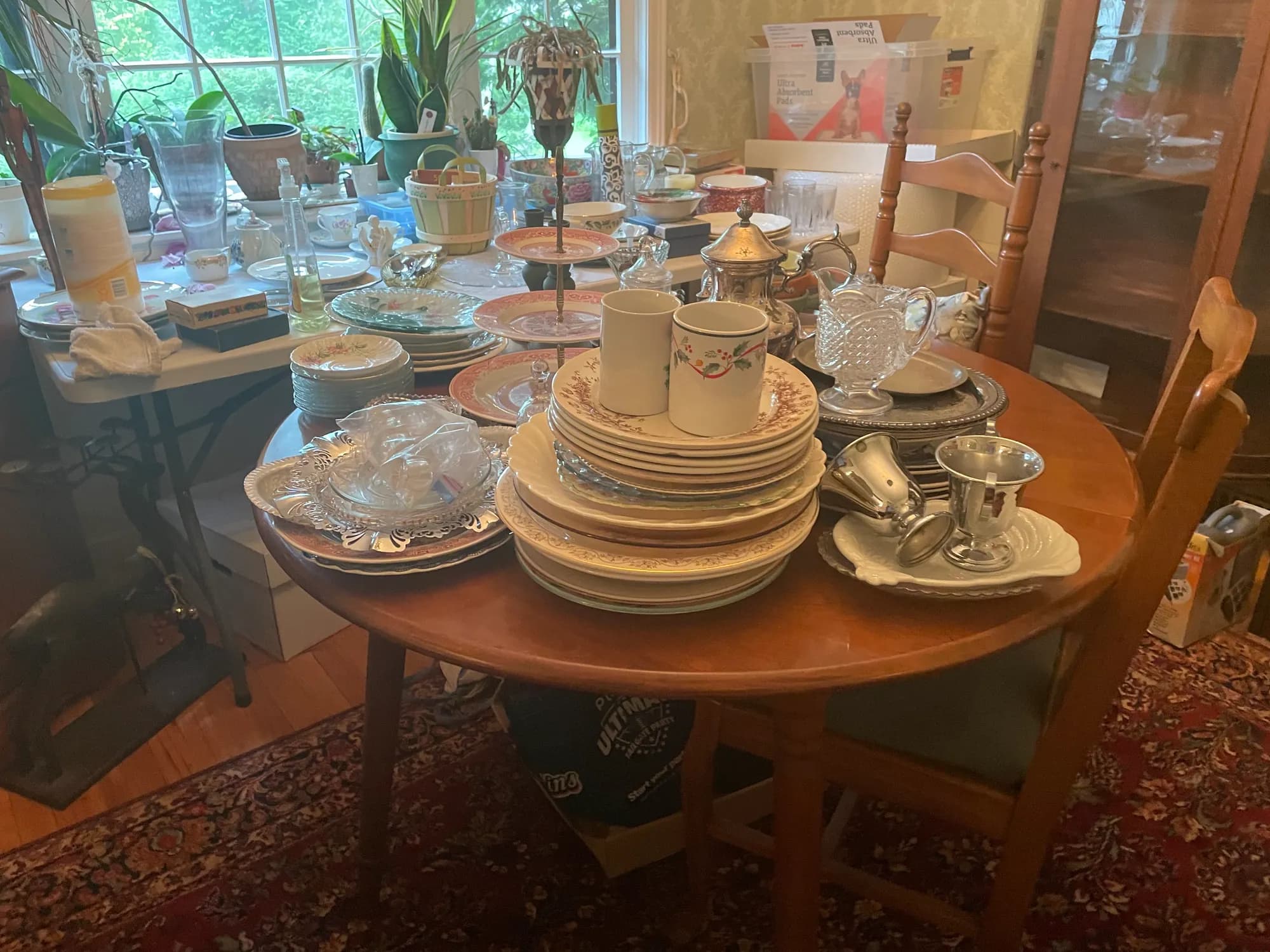 A cabinet stacked with vintage china plates, teacups, and glass dishes.
