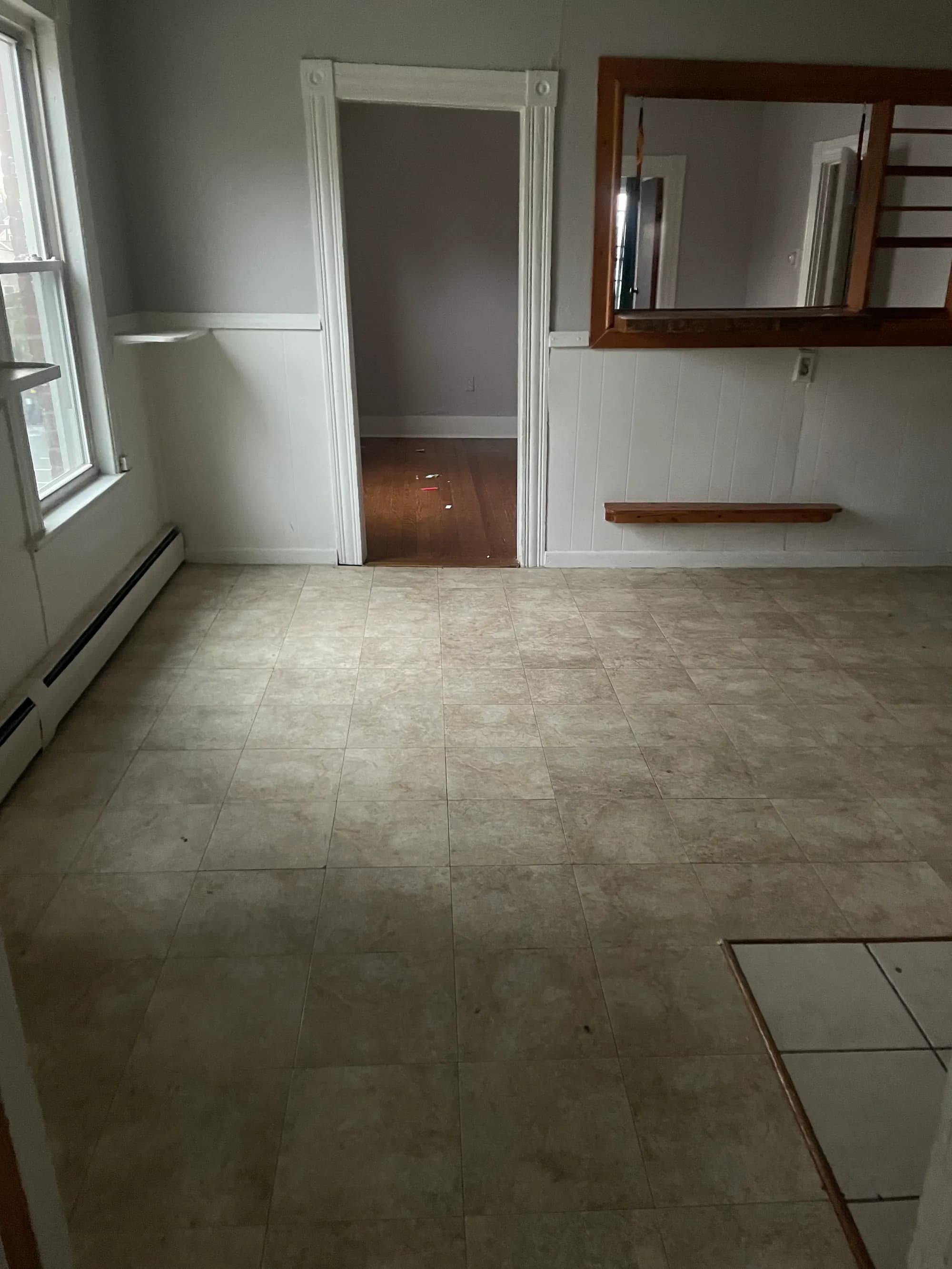 A cleared, swept room after a full cleanout, with a tiled floor and open doorway.