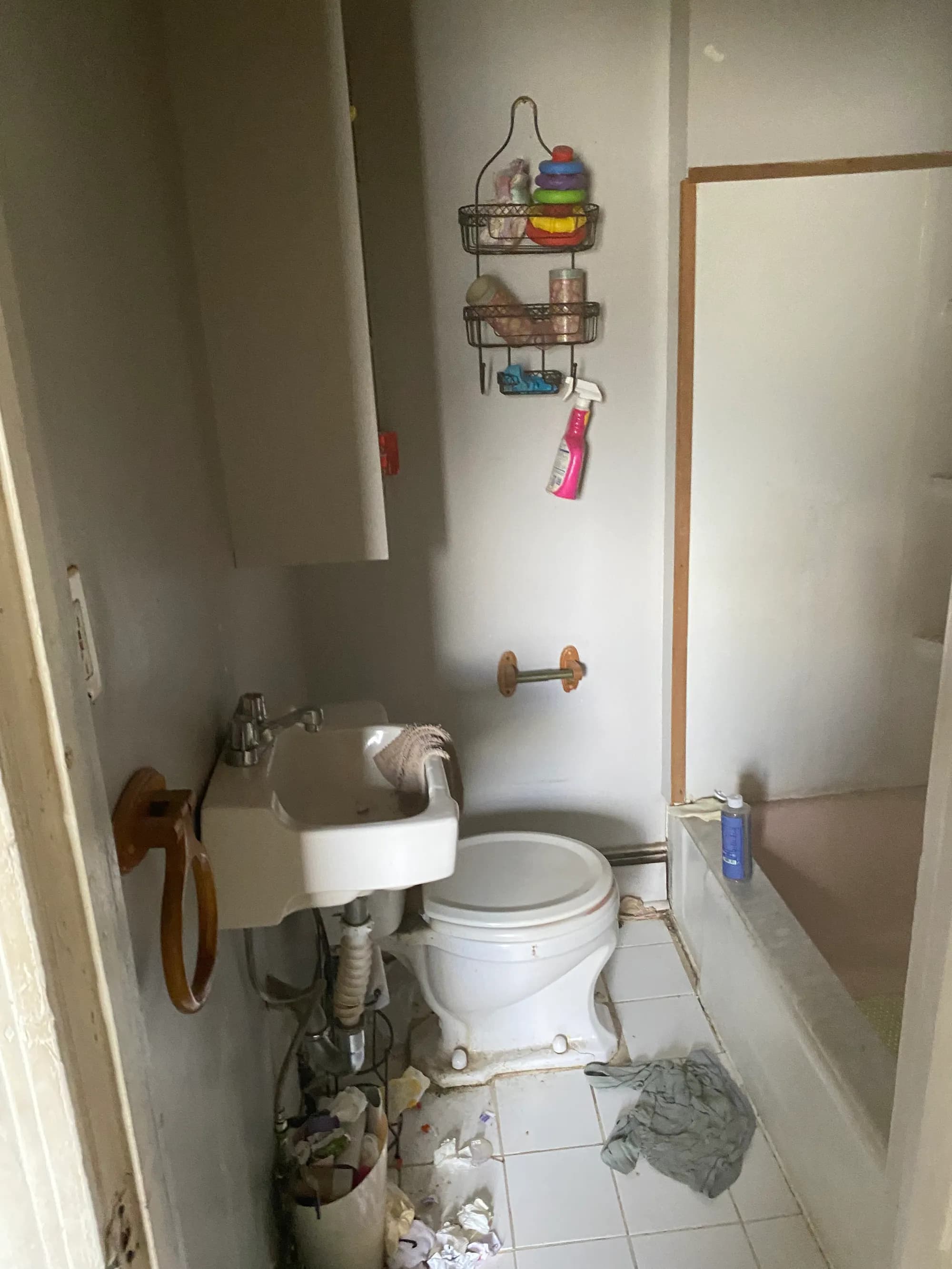 A bathroom being cleared, with fixtures detached from the wall.