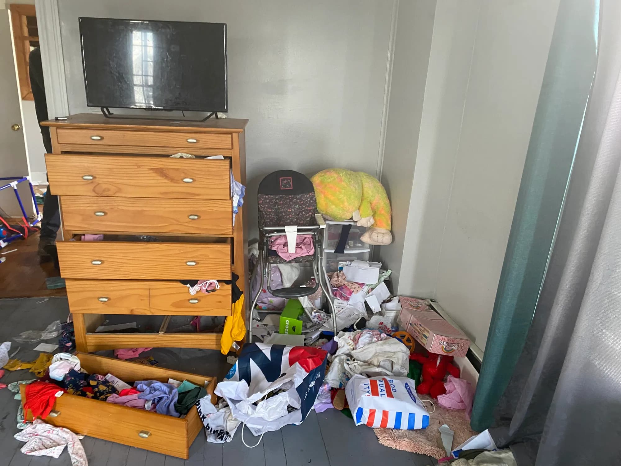 A bedroom with dresser drawers pulled out and scattered belongings.