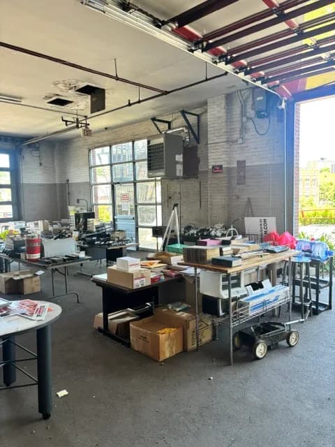 A loft space with folding tables and boxed inventory.